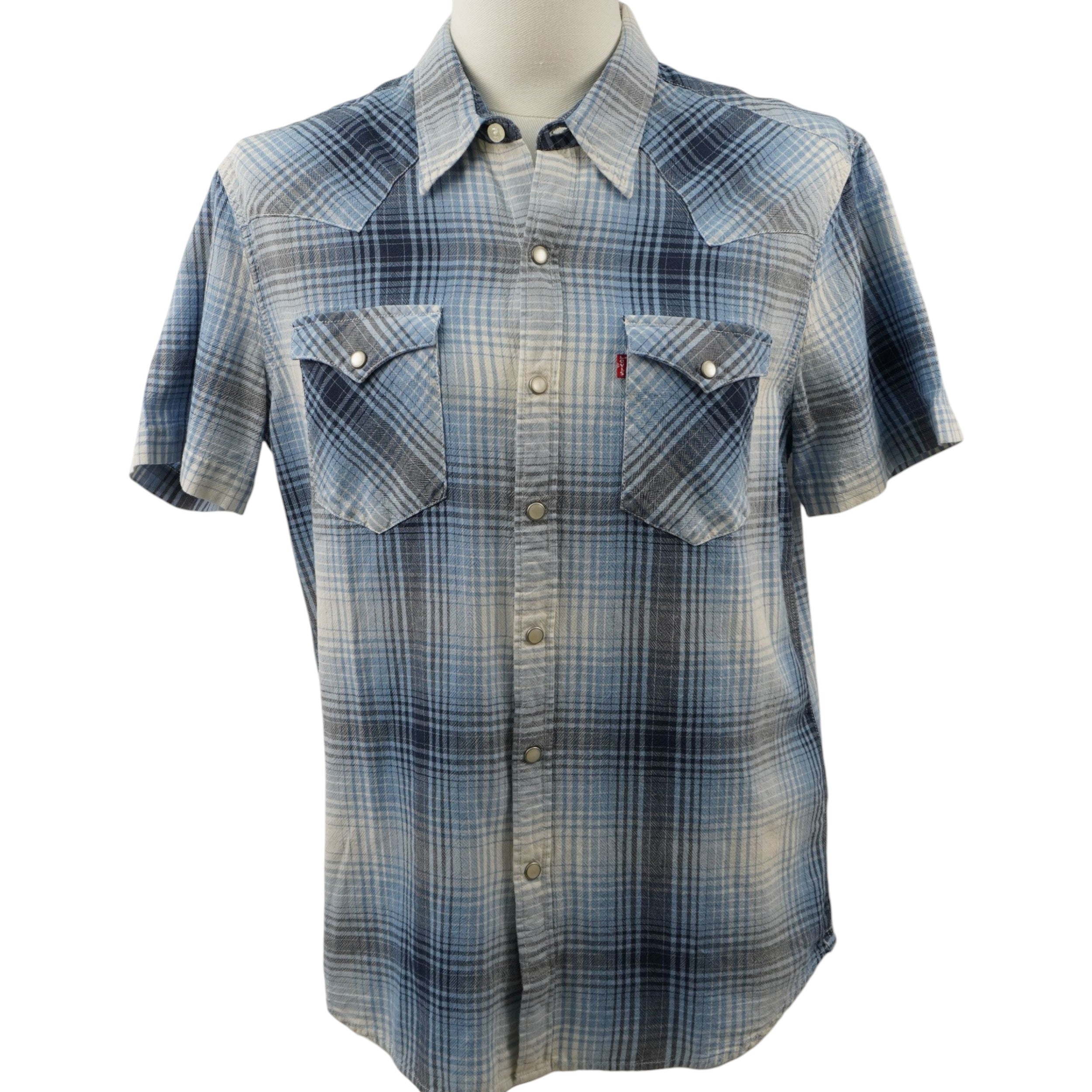 Camicia Levi's modello Western Pearl Snap a maniche corte, fantasia a quadri plaid azzurro, blu e beige. Dettaglio bottoni a pressione madreperla, taschini a punta e Red Tab originale. Taglia M in ottime condizioni vintage.