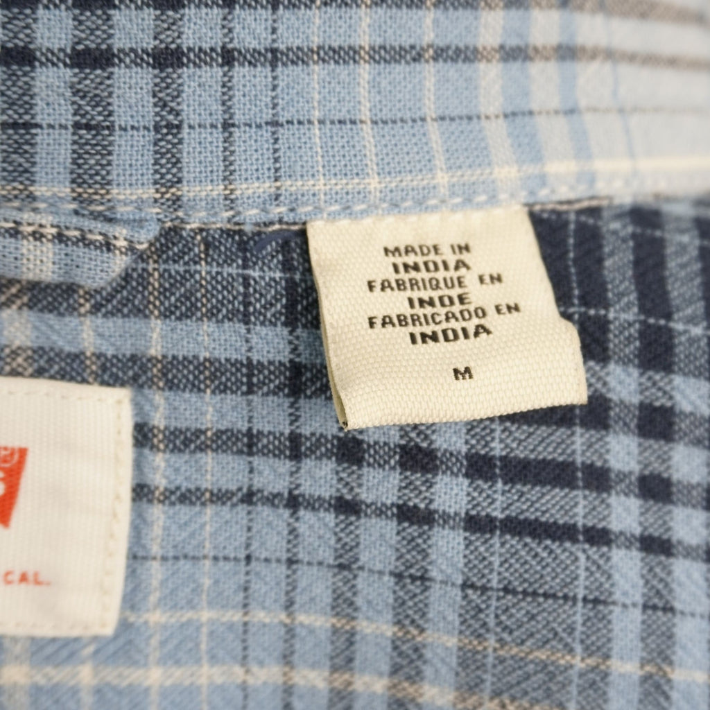 Camicia Levi's modello Western Pearl Snap a maniche corte, fantasia a quadri plaid azzurro, blu e beige. Dettaglio bottoni a pressione madreperla, taschini a punta e Red Tab originale. Taglia M in ottime condizioni vintage.