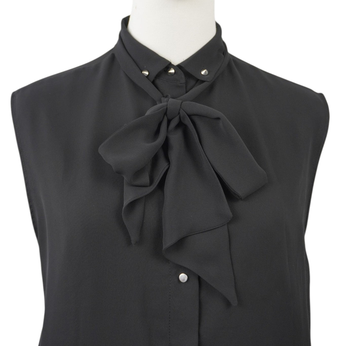 Primo piano del colletto con fiocco decorativo nero, stile bon-ton rock firmato Diesel.