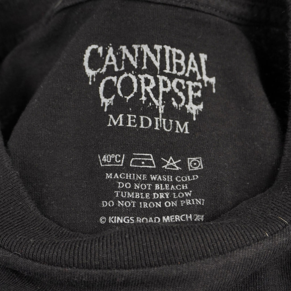 Primo piano dell'interno del colletto della t-shirt che mostra il logo Cannibal Corpse e le informazioni sulla taglia Medium (M) stampate direttamente sul tessuto per un design senza etichetta.