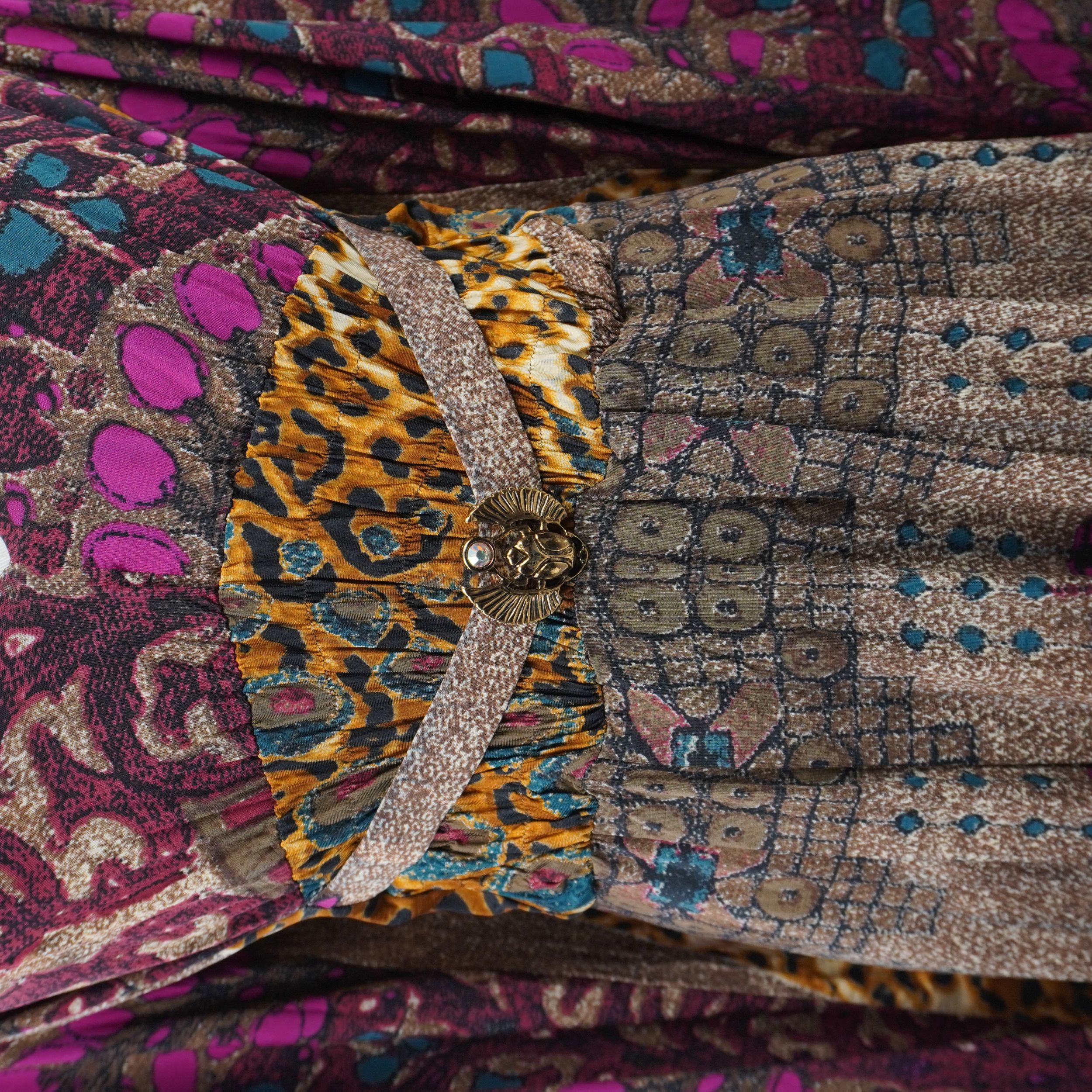 Primo piano della sezione centrale dell'abito con mix di stampe leopardate e damascate, arricchite da filati metallizzati in Lurex.