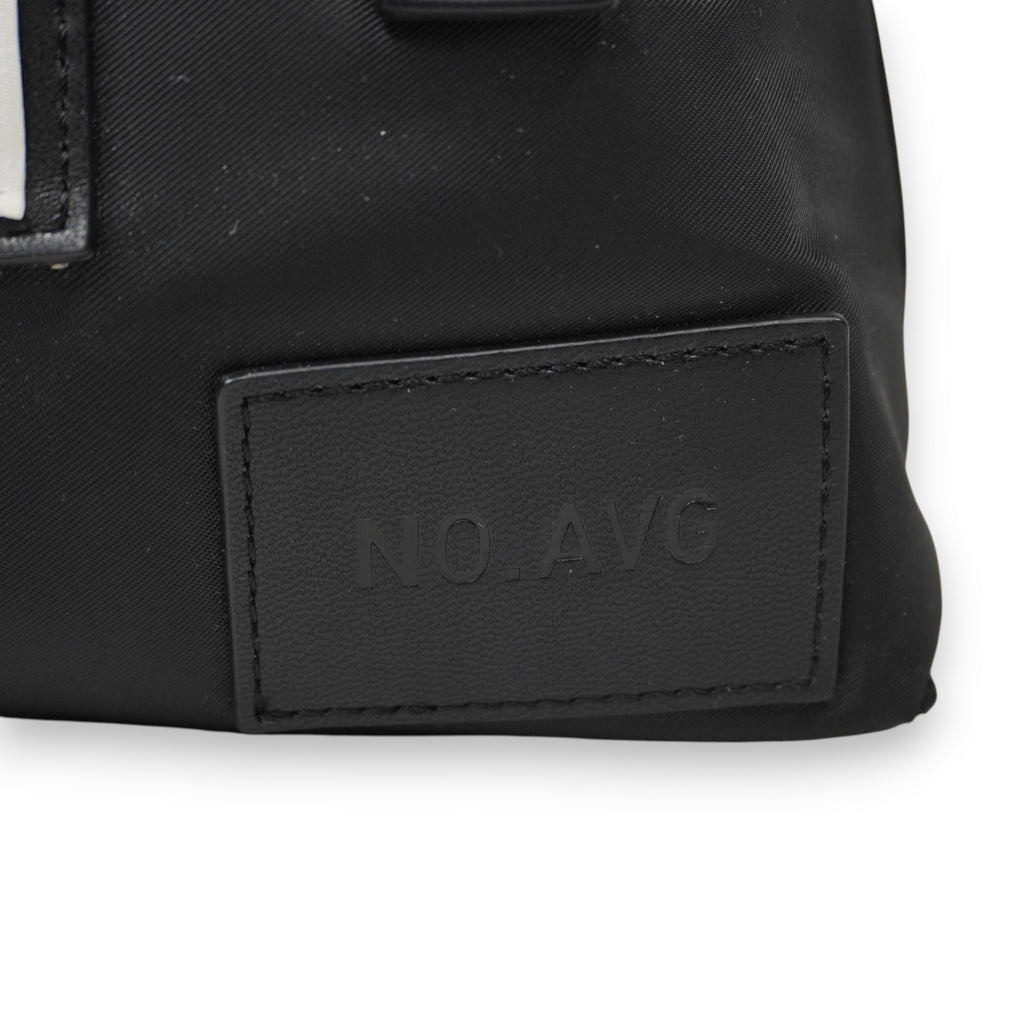 Particolare della label gommata nera in rilievo con la scritta "NO. AVG" (Not Average), dettaglio distintivo della linea.