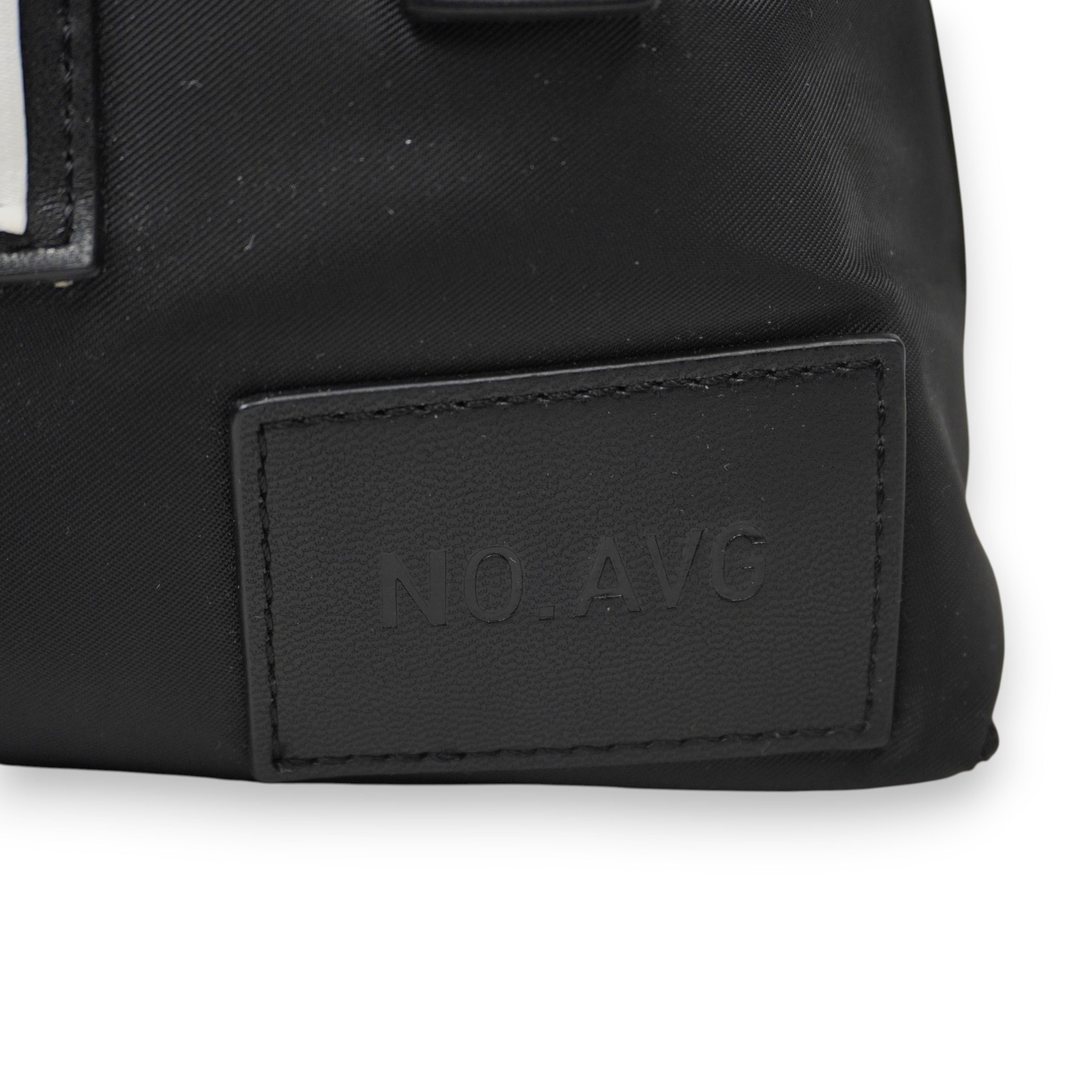 Particolare della label gommata nera in rilievo con la scritta "NO. AVG" (Not Average), dettaglio distintivo della linea.