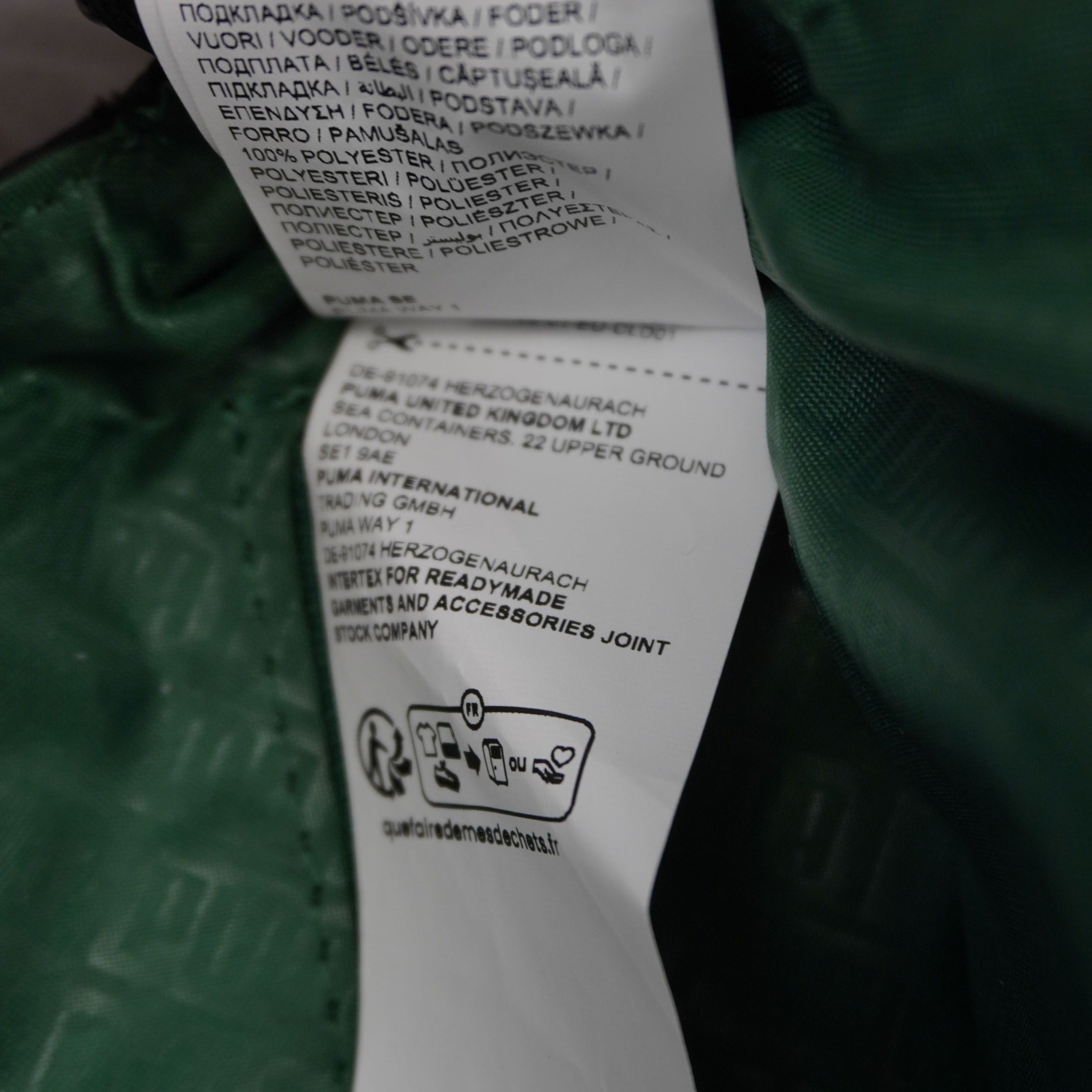 Vista dell'interno borsa con fodera color verde smeraldo a contrasto e etichette ufficiali di produzione.