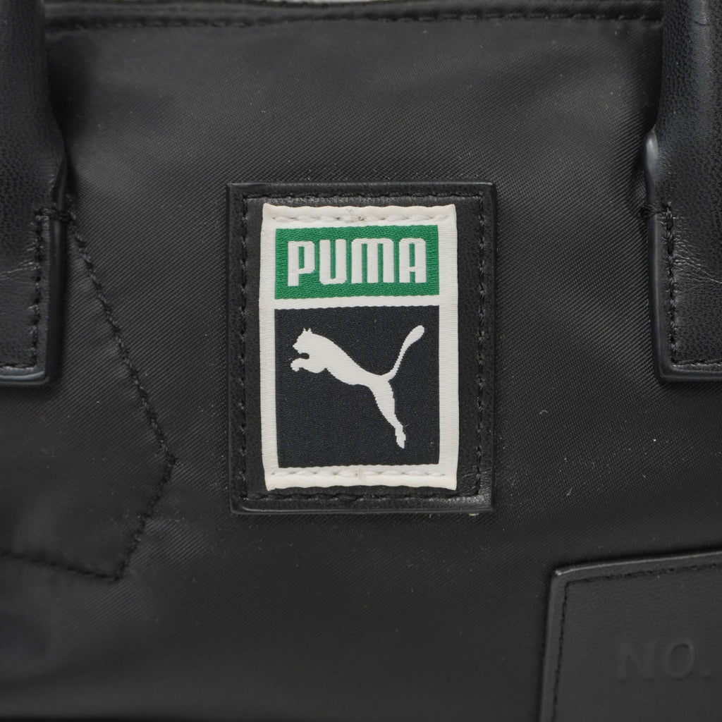  Primo piano del patch ricamato Puma Archive verde, bianco e nero applicato sulla parte frontale della borsa.