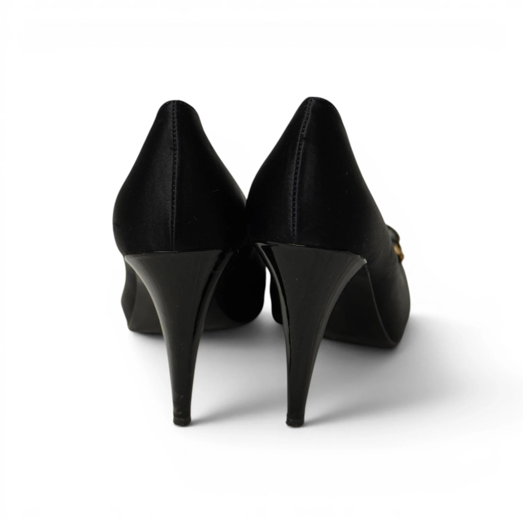 Vista da dietro di due scarpe decollete nere con tacco lucido stile stiletto