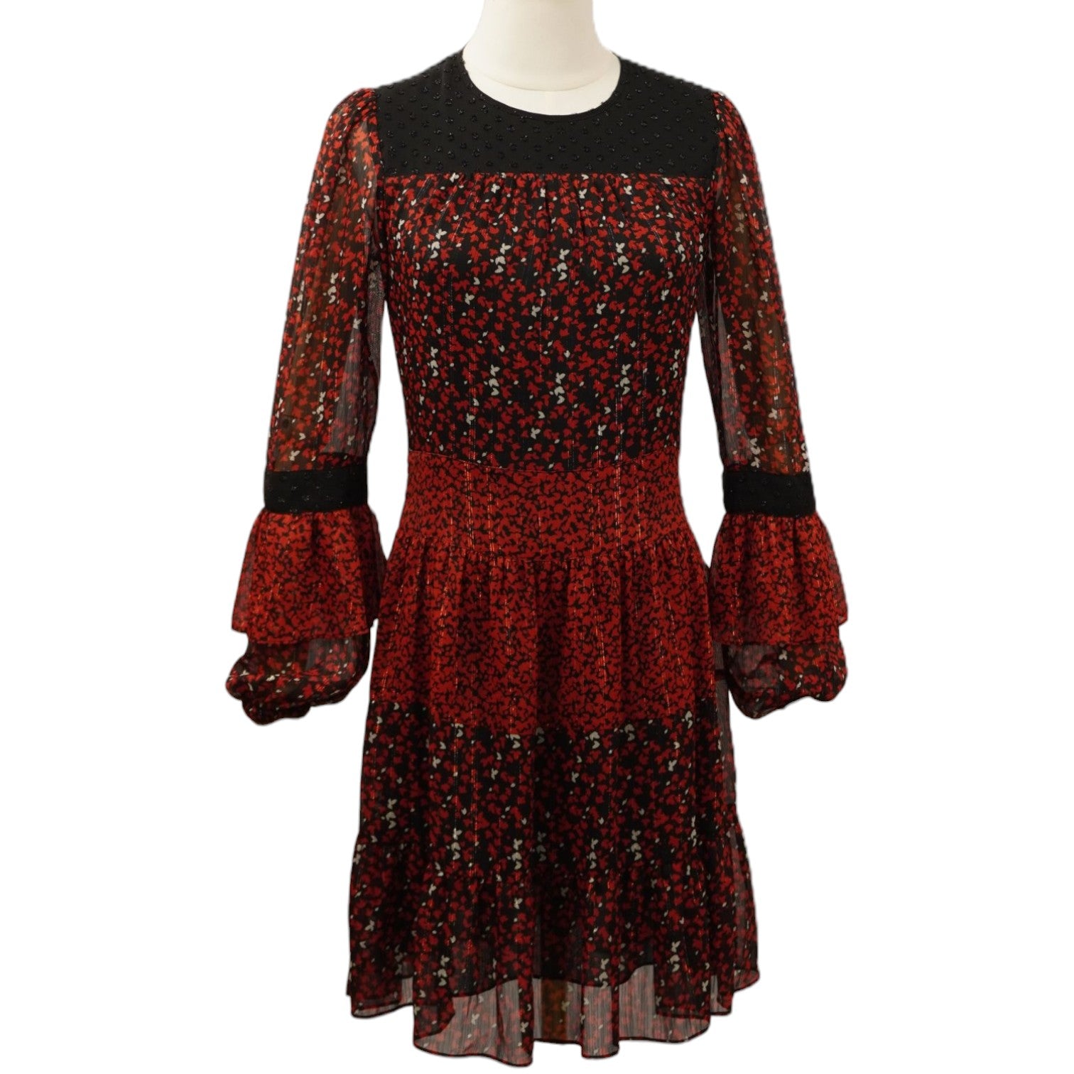 ista frontale del mini abito boho-chic Michael Kors rosso e nero su un manichino, caratterizzato da stampa floreale patchwork, inserti in pizzo e gonna a balze.
