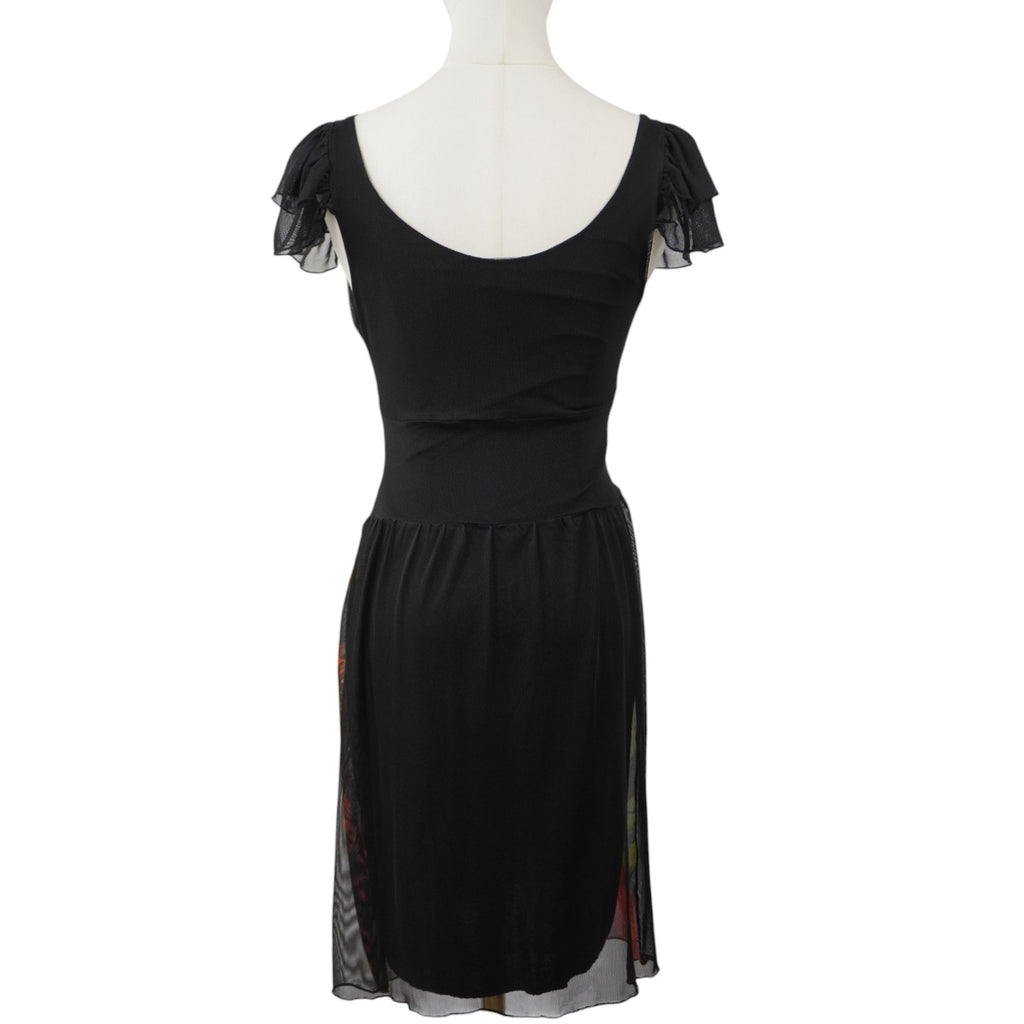 Inquadratura posteriore intera dell'abito Desigual su manichino, che mostra il retro prevalentemente nero, il taglio sciancrato e la scollatura posteriore.