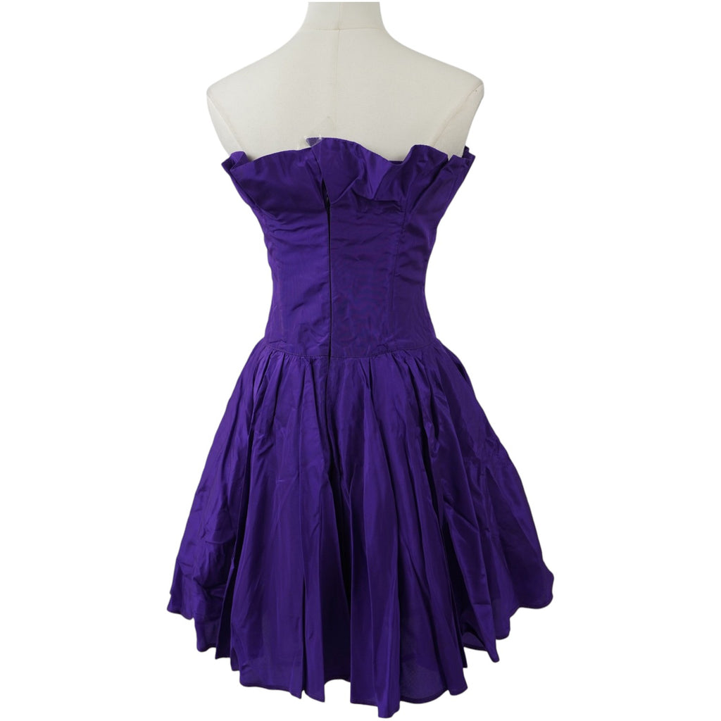 Vista posteriore dell'abito vintage Roccobarocco viola, evidenziando il taglio a corsetto aderente e l'ampiezza della gonna.