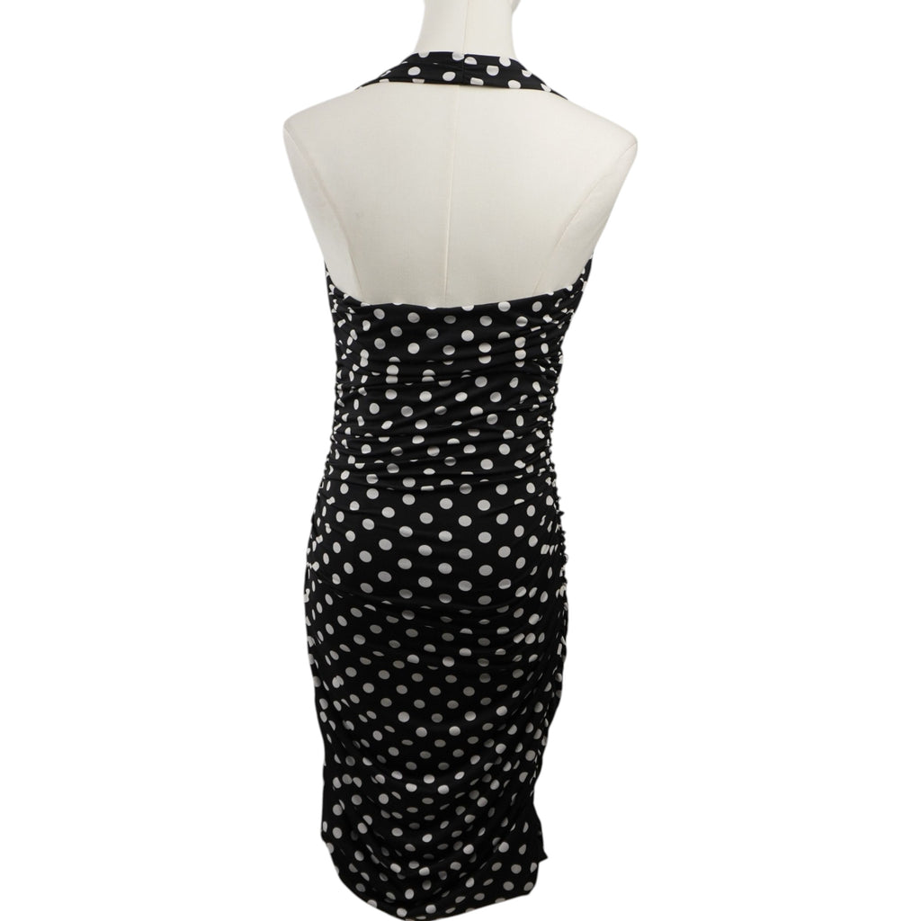 Vestito a pois GUESS nero e bianco visto da dietro, mostra la scollatura halter posteriore e il taglio midi aderente.