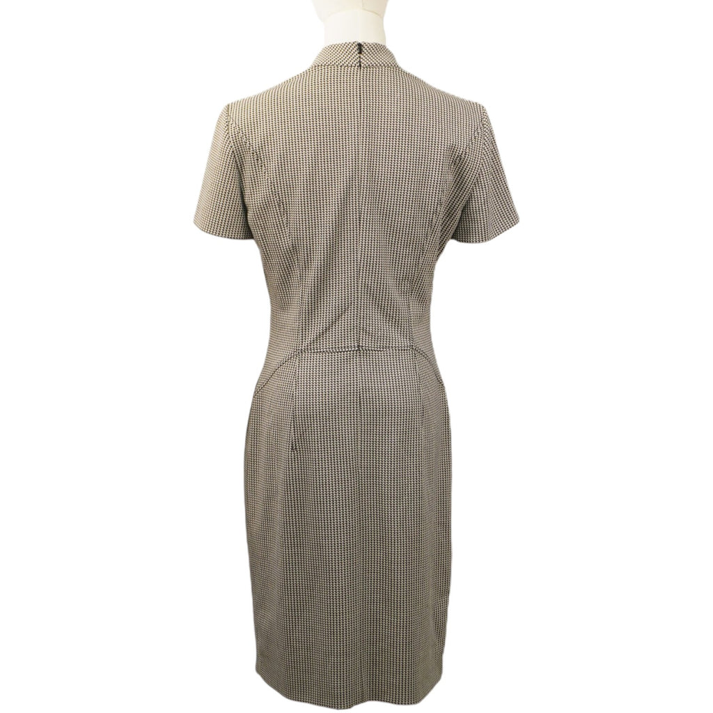 Vista posteriore dell'abito a tubino pied-de-poule sul manichino, che mostra il taglio slim fit e la cerniera centrale.
