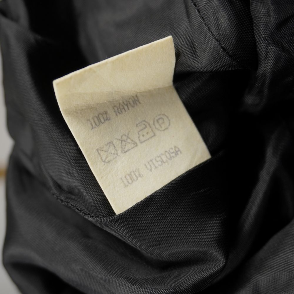 Dettaglio dell'etichetta di lavaggio interna che certifica il tessuto in 100% viscosa rayon con i simboli di cura e manutenzione.