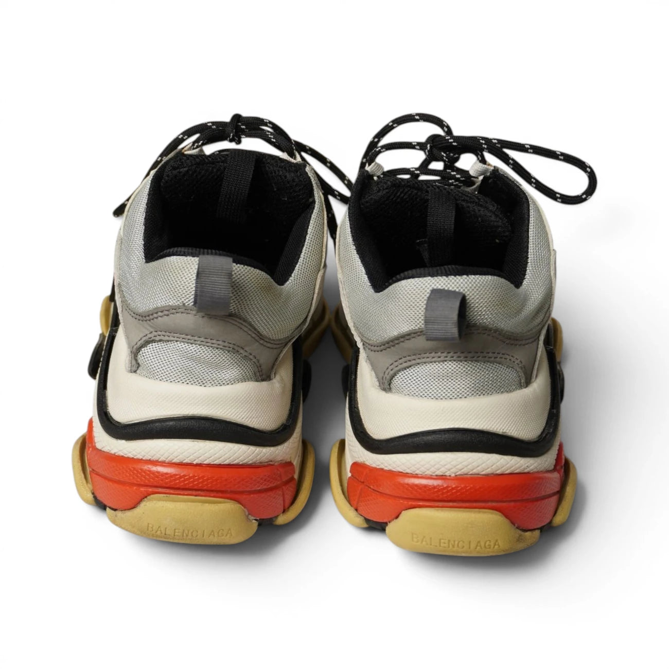 Vista posteriore dei talloni multistrato neri e rossi delle sneaker Balenciaga Triple S.