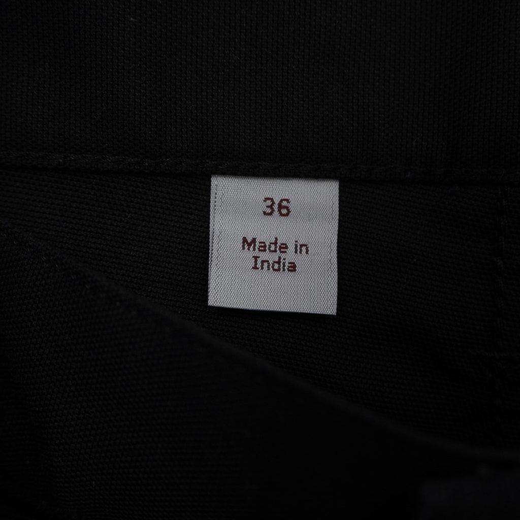 Dettaglio dell'etichetta di lavaggio interna bianca Carhartt WIP con codici della collezione Primavera 2019 e taglia W36
