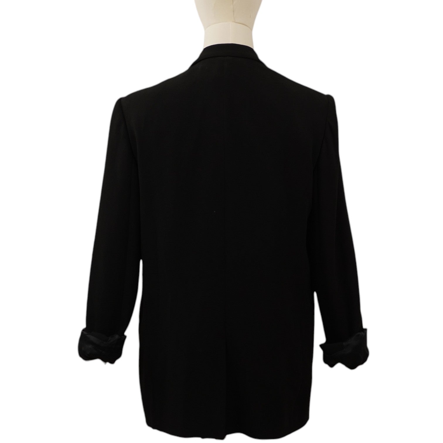 Vista posteriore del blazer nero sartoriale sul manichino, che mostra il taglio dritto e la linea pulita delle spalle.