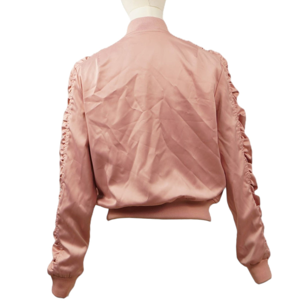 Vista posteriore del bomber rosa cipria satinato sul manichino, che mostra il taglio corto, i bordi a costine e l'arricciatura lungo le maniche.