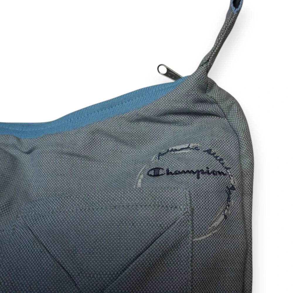 Ingrandimento del logo Champion ricamato in blu notte sul fronte della borsa con scritta circolare Authentic Athletic Apparel.