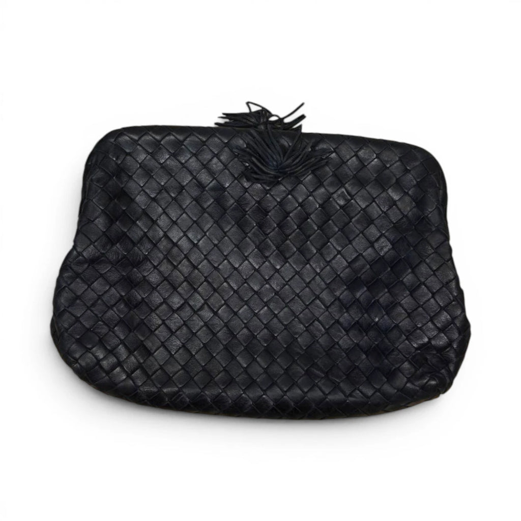 Borsa clutch vintage Bottega Veneta in pelle nera intrecciata con dettaglio nappa su sfondo bianco.