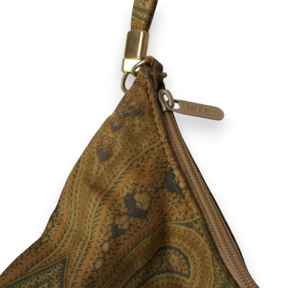 Zoom laterale sulla chiusura a cerniera lampo con cursore logato ETRO e aggancio rettangolare metallico color oro del manico.