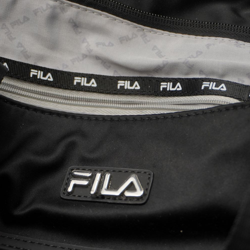 Interno della borsa shopper FILA foderato in tessuto grigio con logo all-over e tasca di sicurezza con zip profilata in bianco e nero.