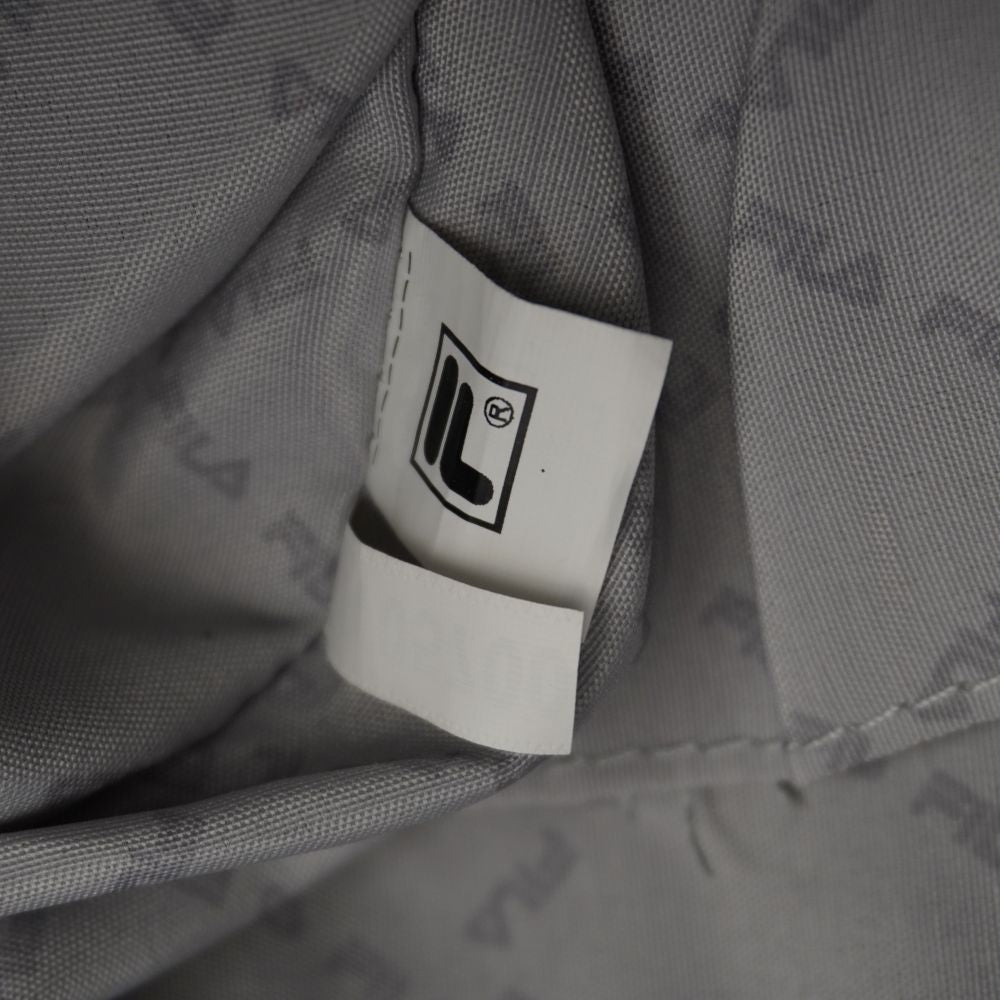 Vista interna delle tasche aperte a bustina con l'etichetta ufficiale in tessuto bianco stampata con l'iconico logo F-Box di FILA.