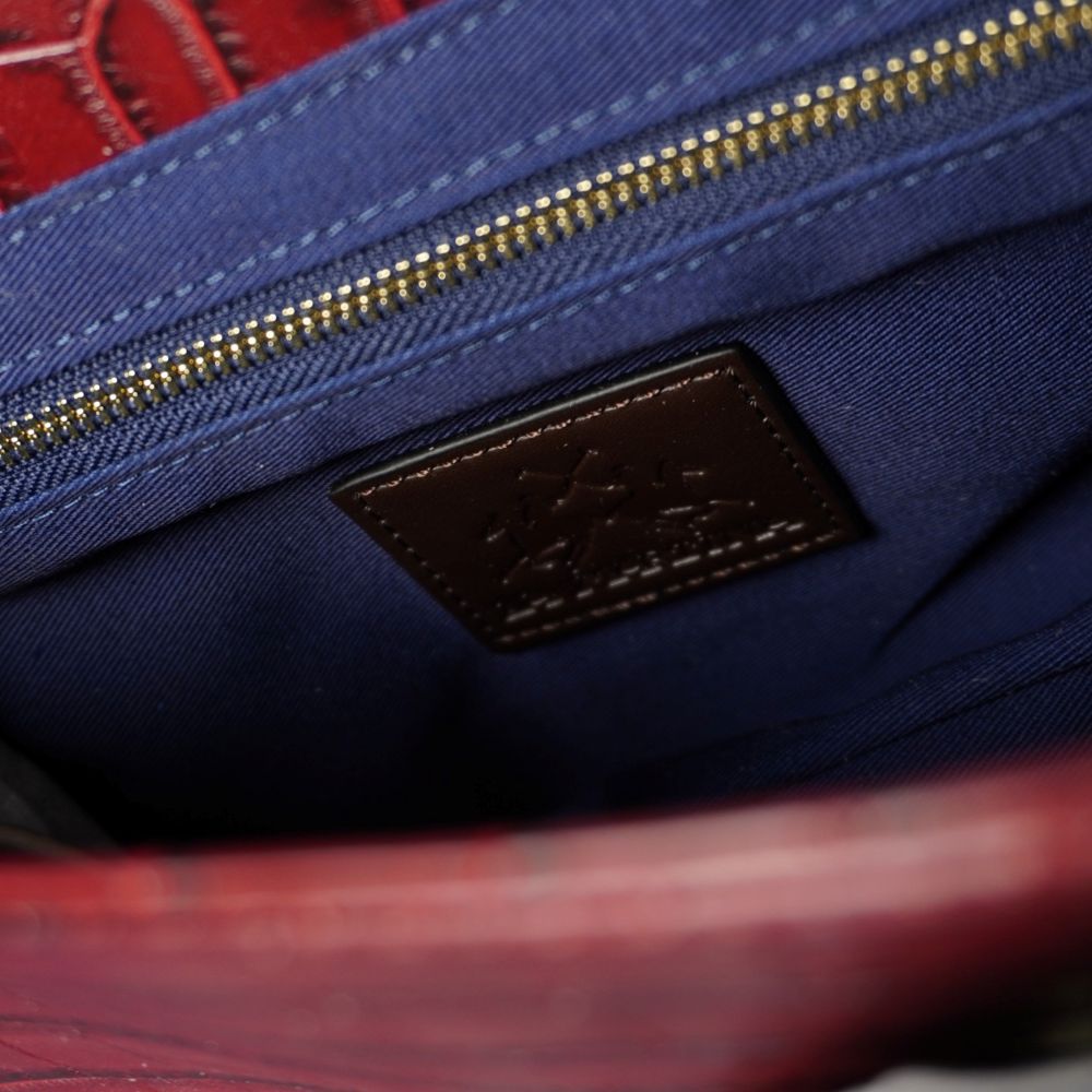  Interno della borsa La Martina con fodera in tessuto blu navy, tasca interna dotata di chiusura a zip dorata e patch in pelle marrone con logo.