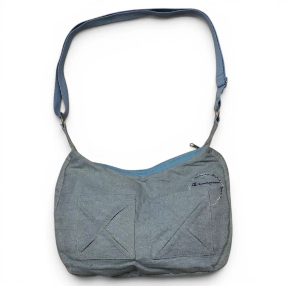Vista frontale completa su sfondo bianco della borsa a tracolla Champion vintage in tela grigia con tasche utility a incrocio e profili azzurri.