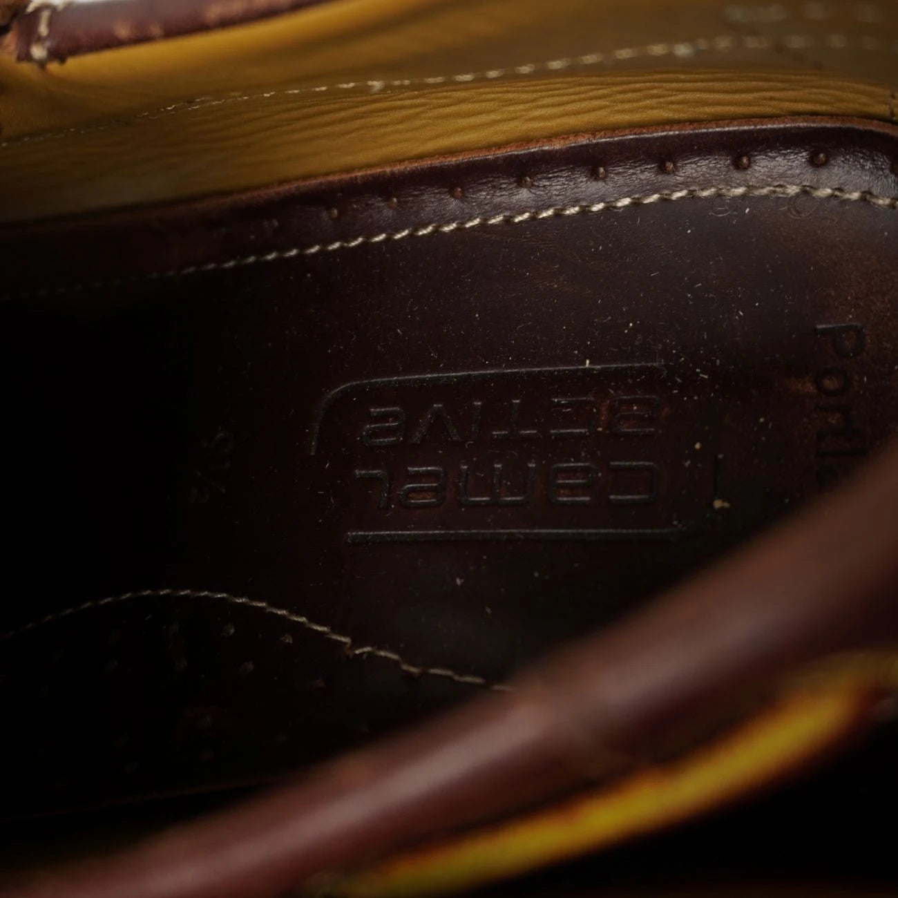 Primo piano della parte interna posteriore della scarpa con il logo Camel Active stampato a caldo sulla soletta in vera pelle