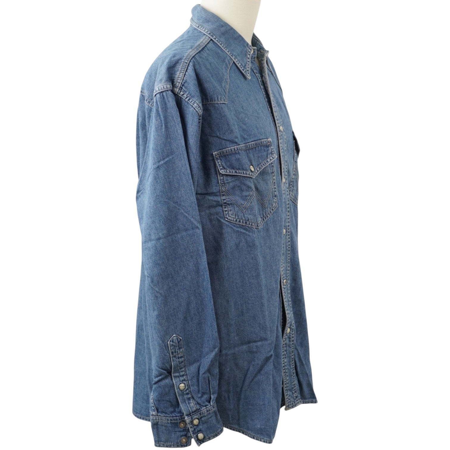 Vista laterale di profilo della camicia di jeans Wrangler indossata dal manichino, che mostra la lunghezza e la linea della manica.