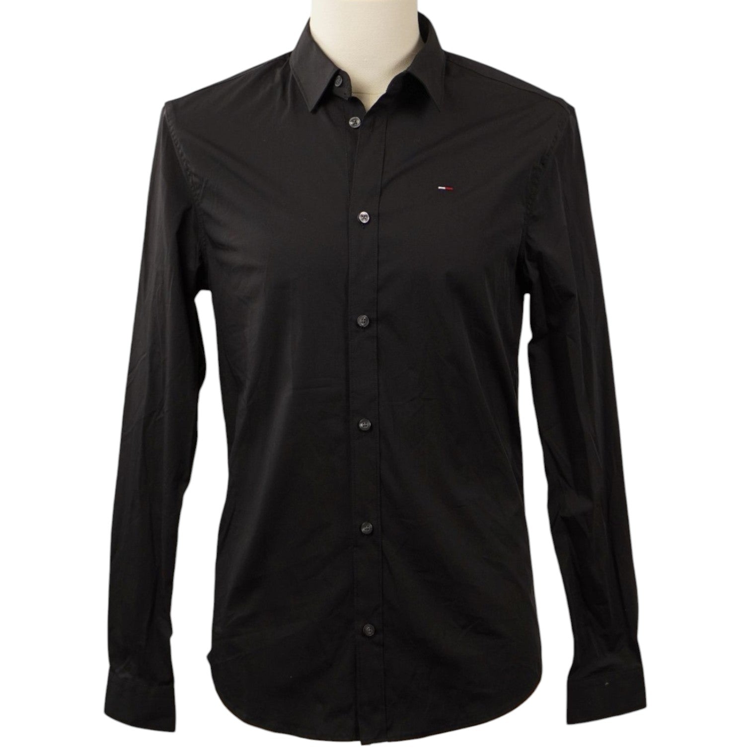 Vista frontale su manichino di una camicia a maniche lunghe nera Tommy Jeans in popeline di cotone elasticizzato, con linea aderente Slim Fit.