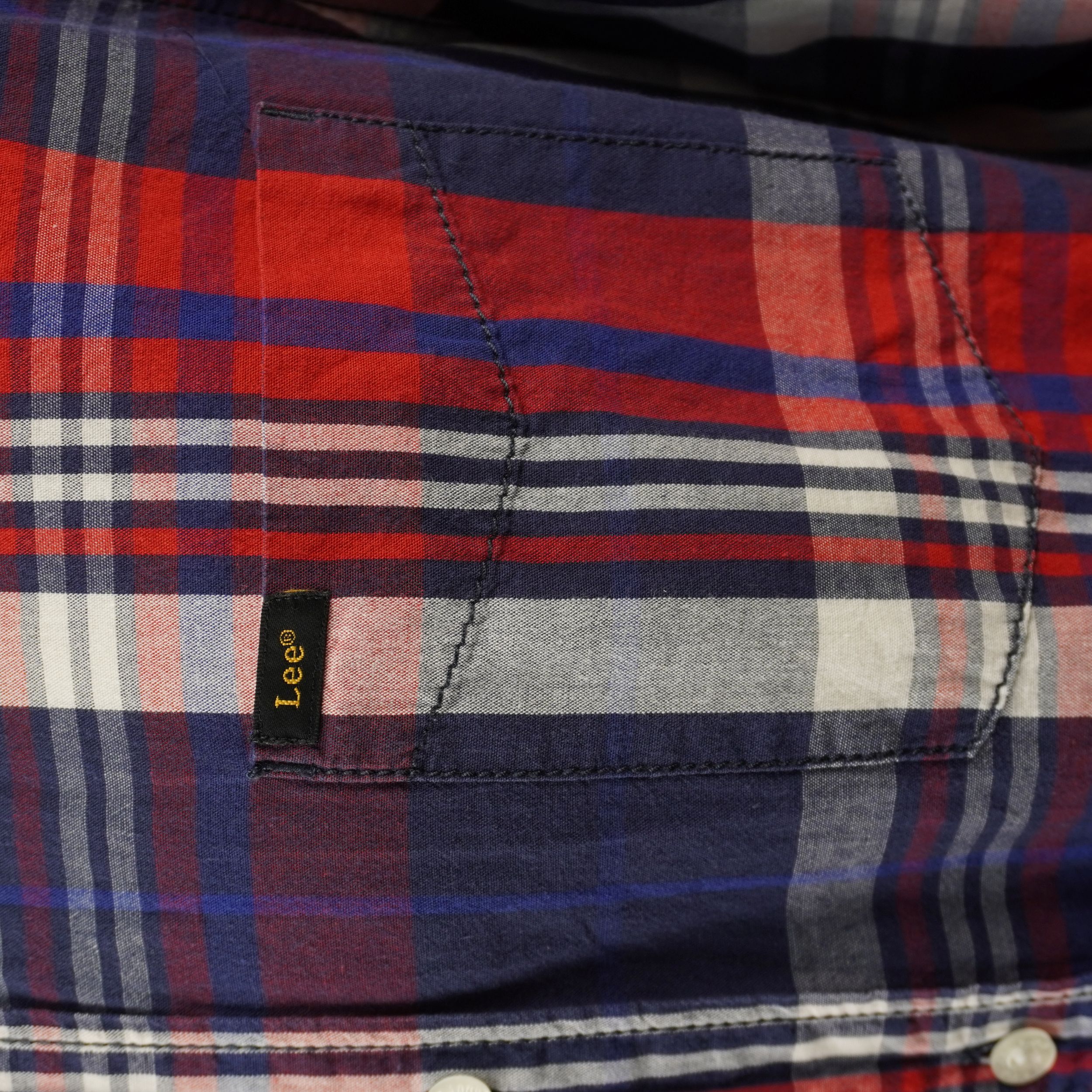 Primo piano del pattern a quadri scozzesi e delle cuciture della camicia Lee.