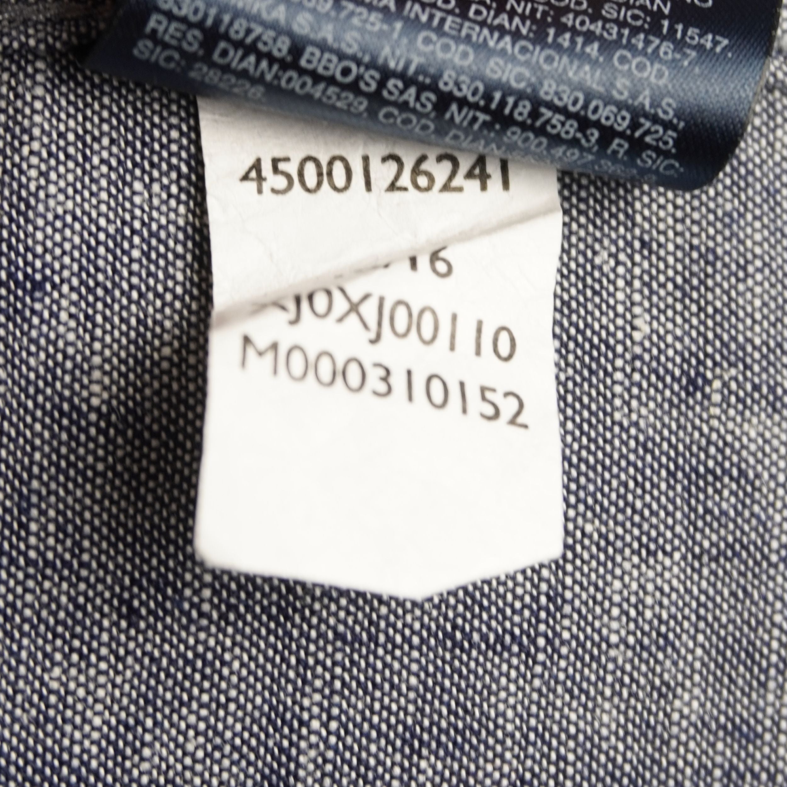 Etichetta interna di composizione: 55% cotone e 45% lino, con codici di produzione per certificare l'originalità del capo.