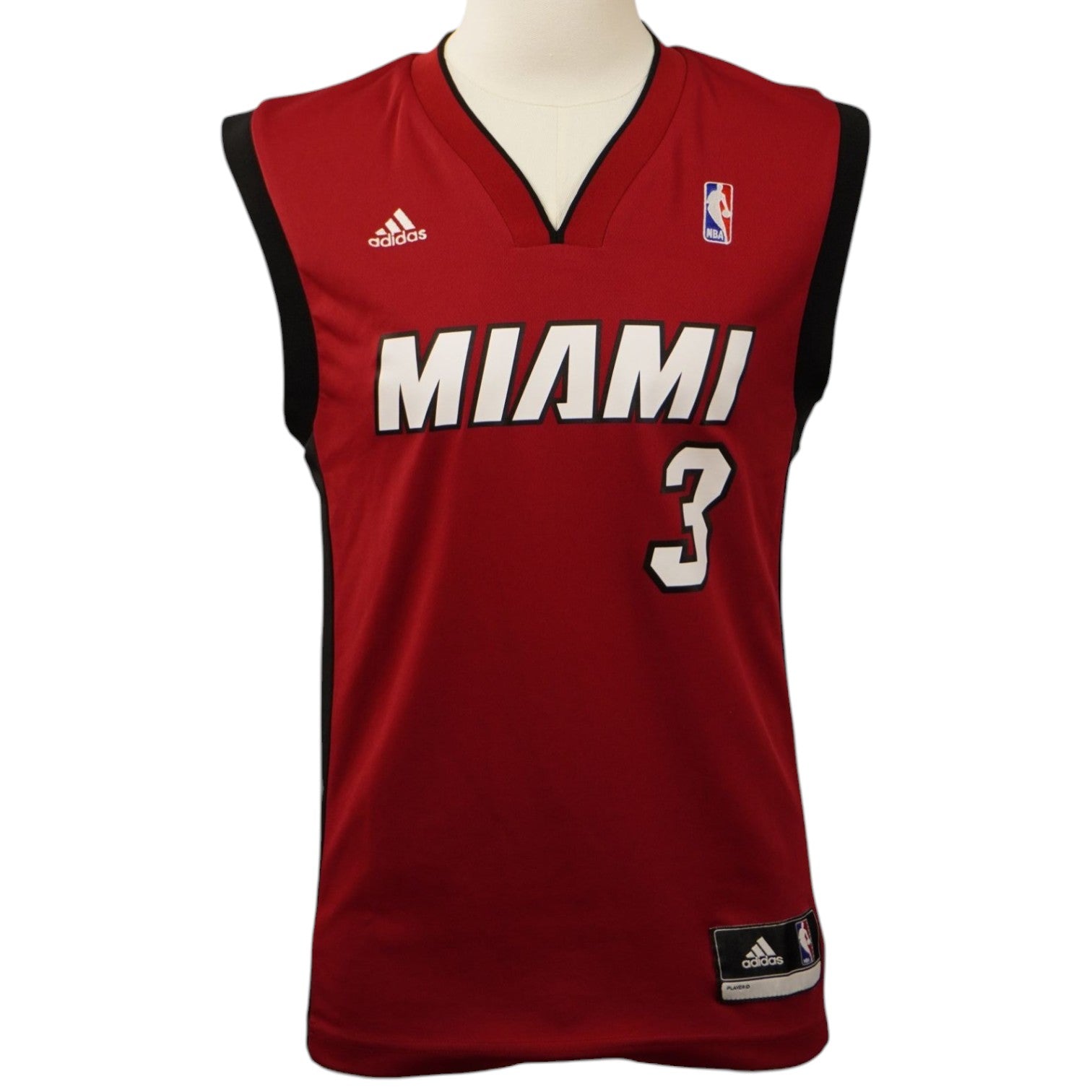 Vista frontale della canotta rossa dei Miami Heat Adidas su un manichino, con la scritta Miami e il numero 3 di Dwyane Wade sul petto.
