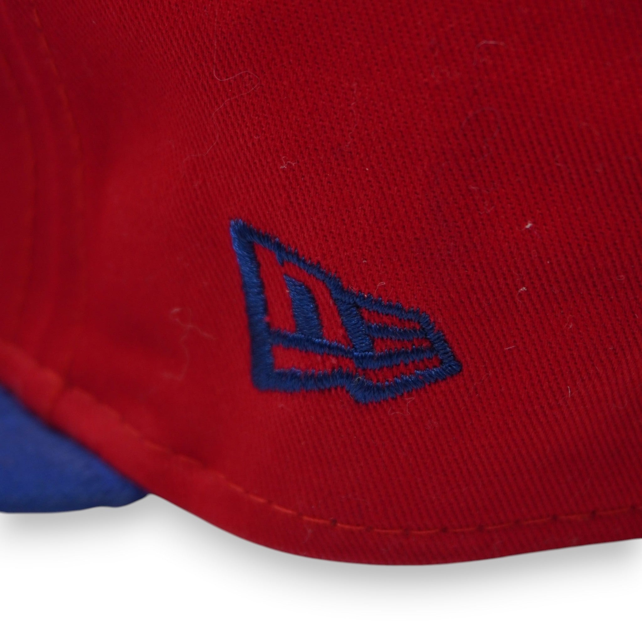 Zoom sul pannello laterale rosso con l'iconica bandiera New Era ricamata in filo blu navy ad alta densità.