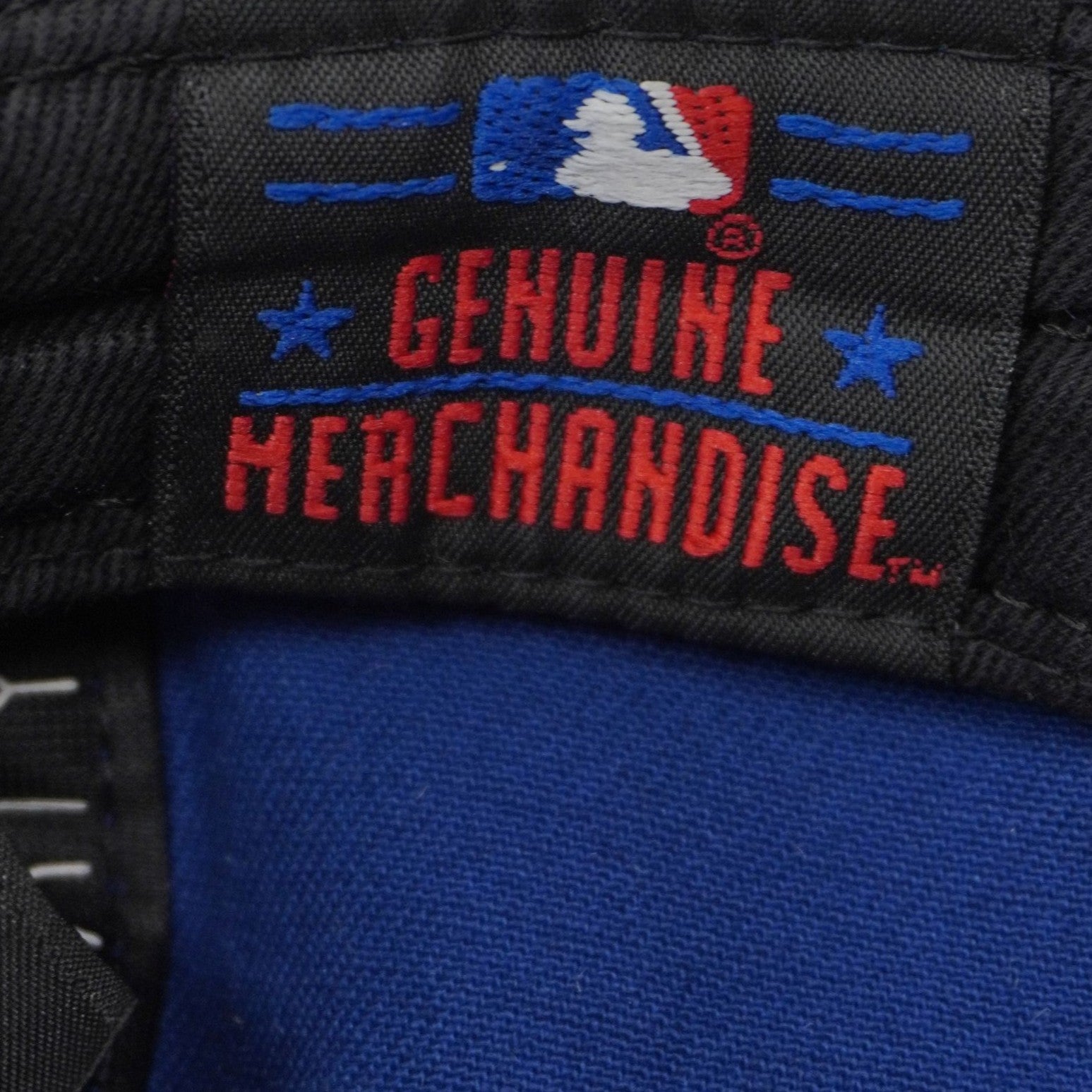 Etichetta interna in tessuto nero Genuine Merchandise della Major League Baseball con il logo del battitore MLB ricamato.