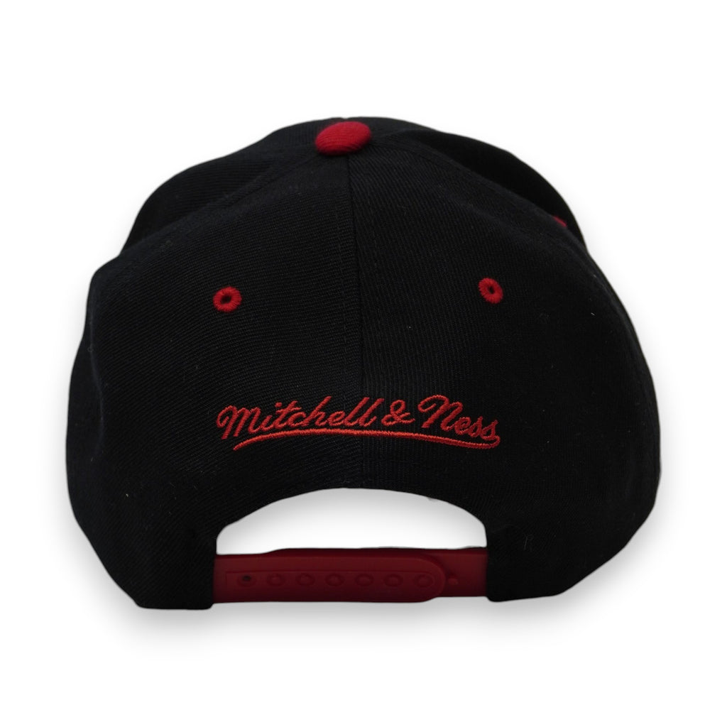 Vista posteriore del cappellino con chiusura snapback rossa e logo Mitchell & Ness ricamato in corsivo sopra l'apertura.