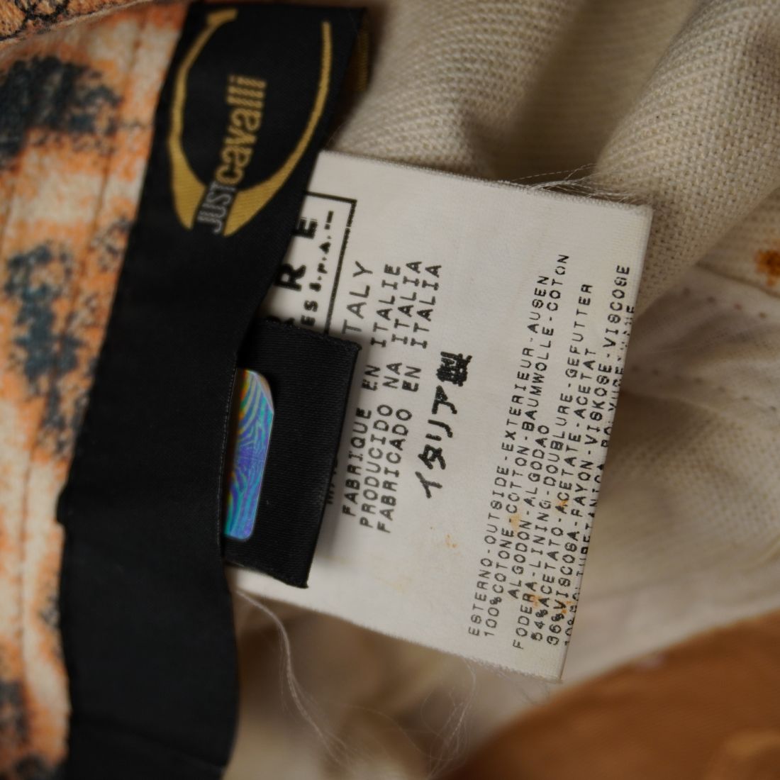 Dettaglio delle etichette interne in tessuto che attestano il Made in Italy e la composizione in 100% cotone.
