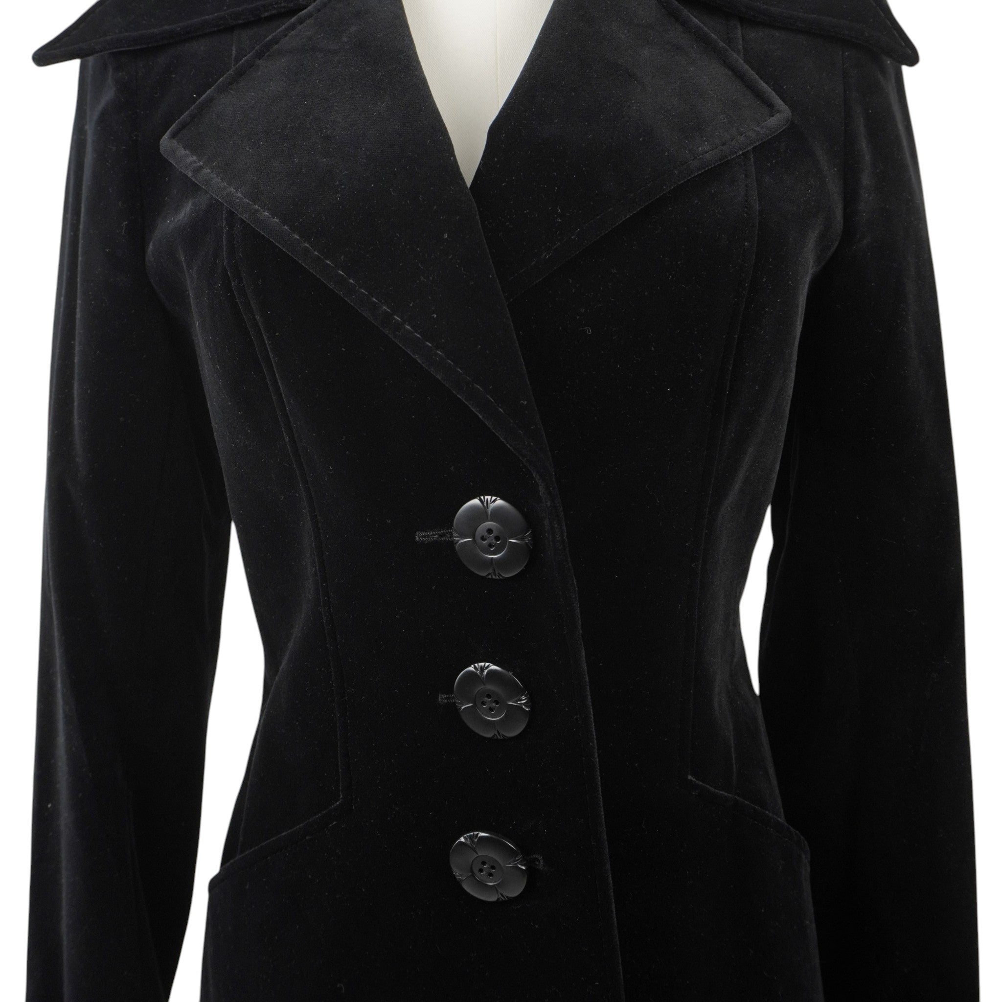 Primo piano della parte superiore del cappotto con rever ampi e bottoni neri a rilievo con design floreale.