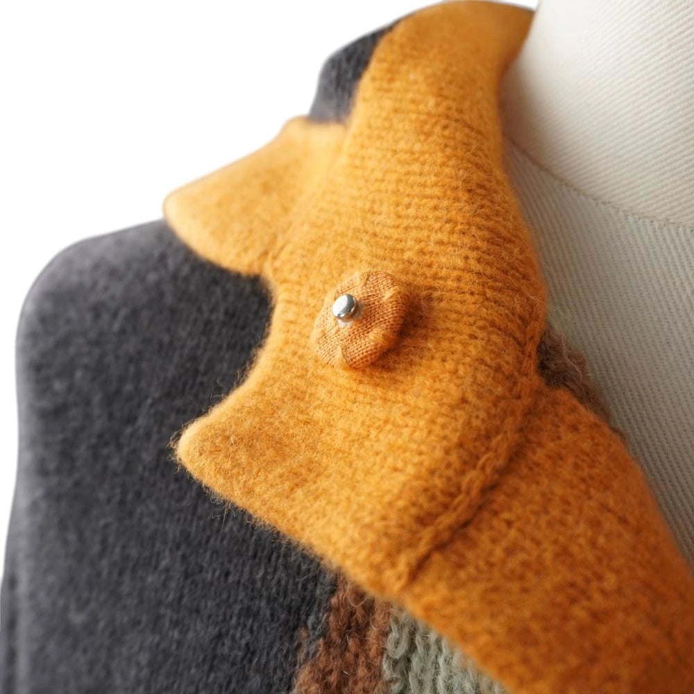  Dettaglio del bottone automatico rivestito in lana arancione con perno metallico centrale sul colletto del cardigan Missoni.