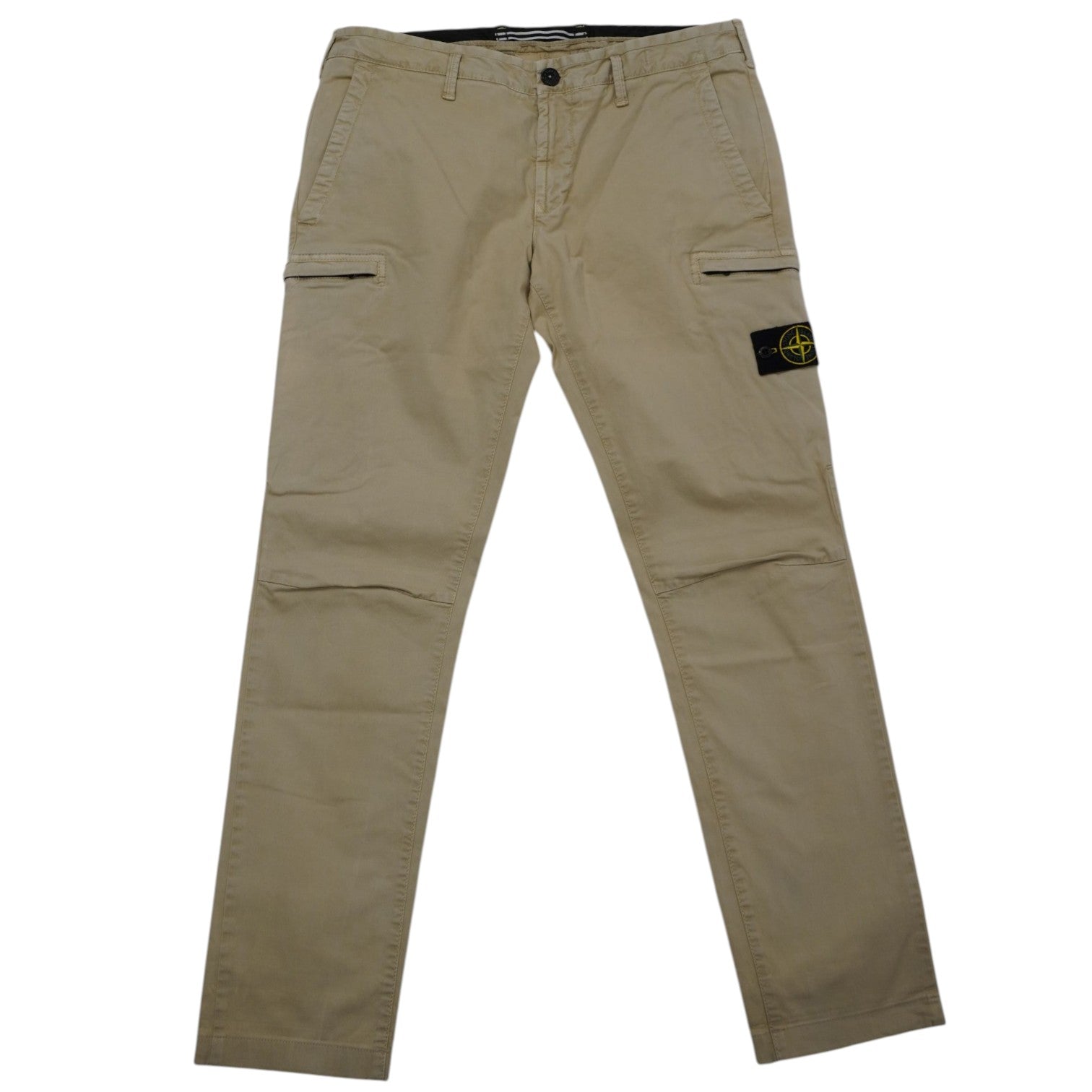 Vista frontale completa del pantalone cargo Stone Island steso, con tasche laterali e il badge rimovibile visibile sulla gamba sinistra.