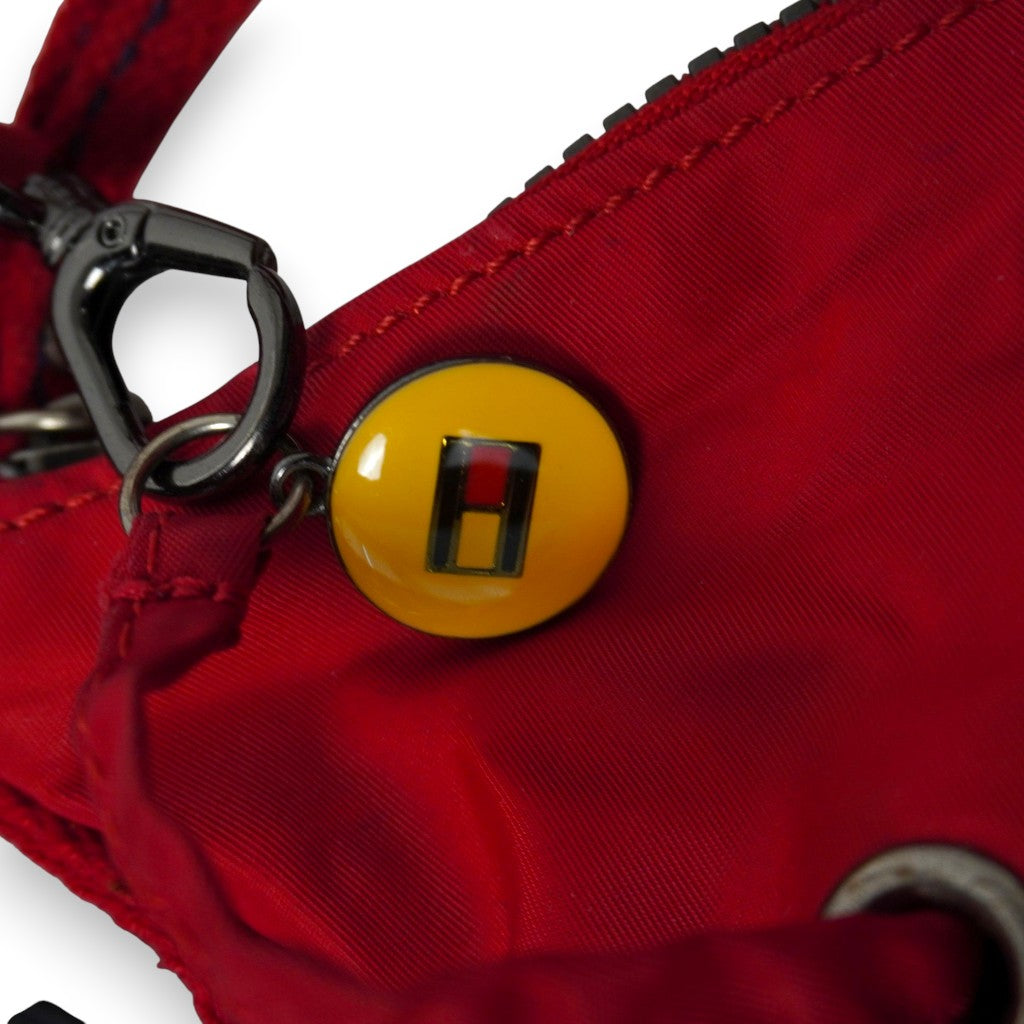 Zoom sul ciondolo rotondo giallo smaltato con la lettera H stilizzata e la bandierina istituzionale Tommy Hilfiger.