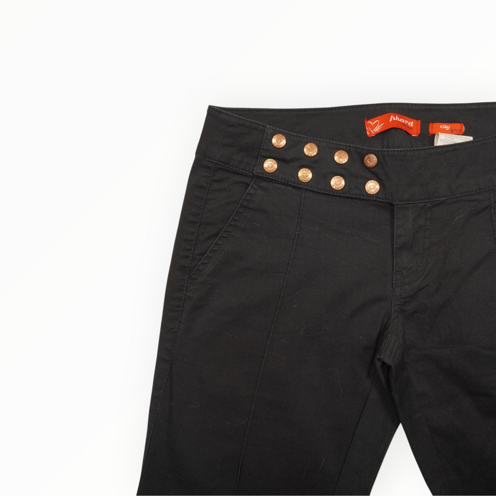 Primo piano del pannello di chiusura asimmetrico frontale con doppia fila di bottoni metallici color rame lucido firmati Phard Jeans.
