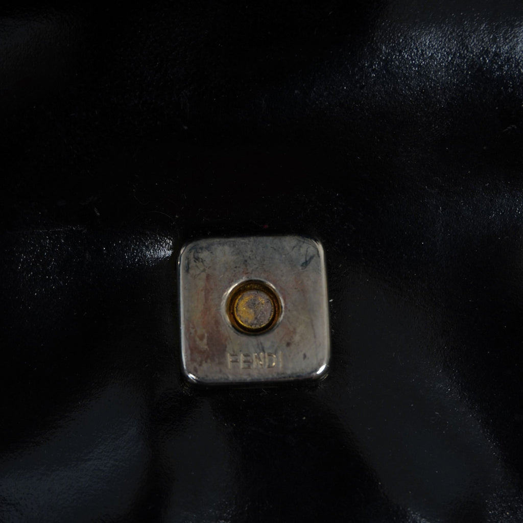 Particolare del bottone magnetico a scomparsa e della minuteria metallica originale della borsa Fendi d'archivio.