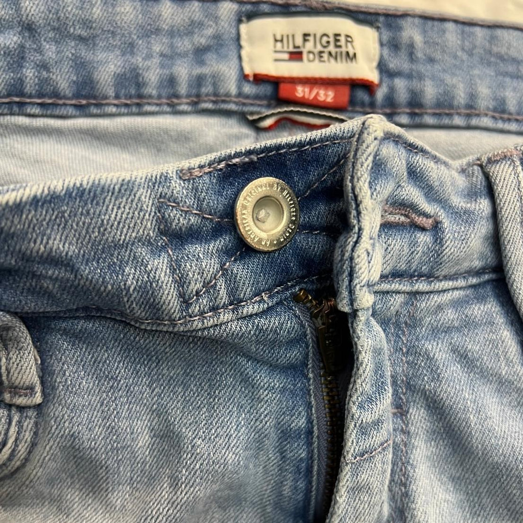 Vista ravvicinata del bottone metallico principale e della chiusura frontale dei jeans Hilfiger Denim Saber.