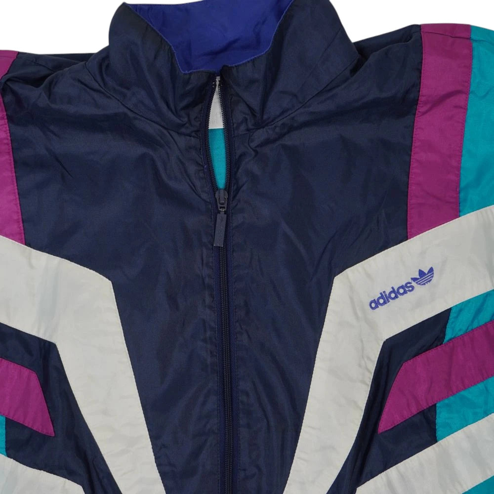 Inquadratura ravvicinata della cerniera lampo navy e del colletto alto della giacca Adidas