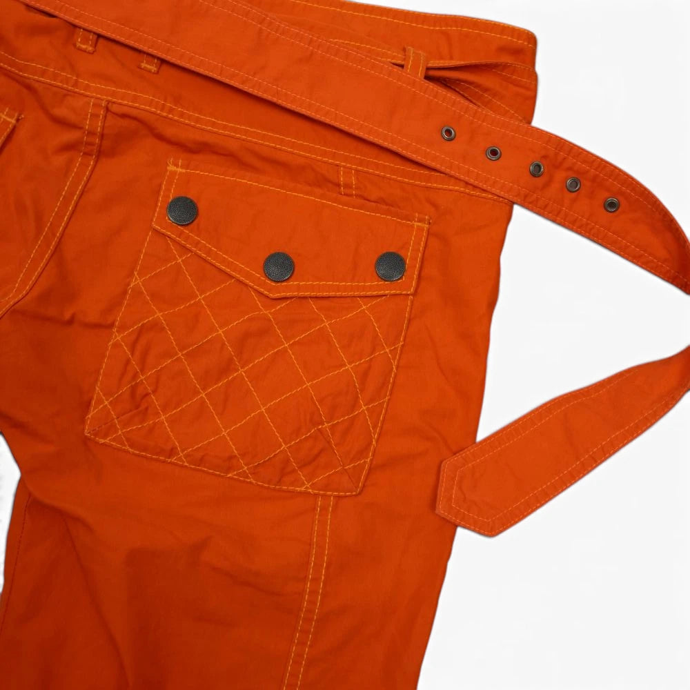 Primo piano della maxi cintura in tessuto arancione inserita nei passanti robusti dei pantaloni cargo Diesel.