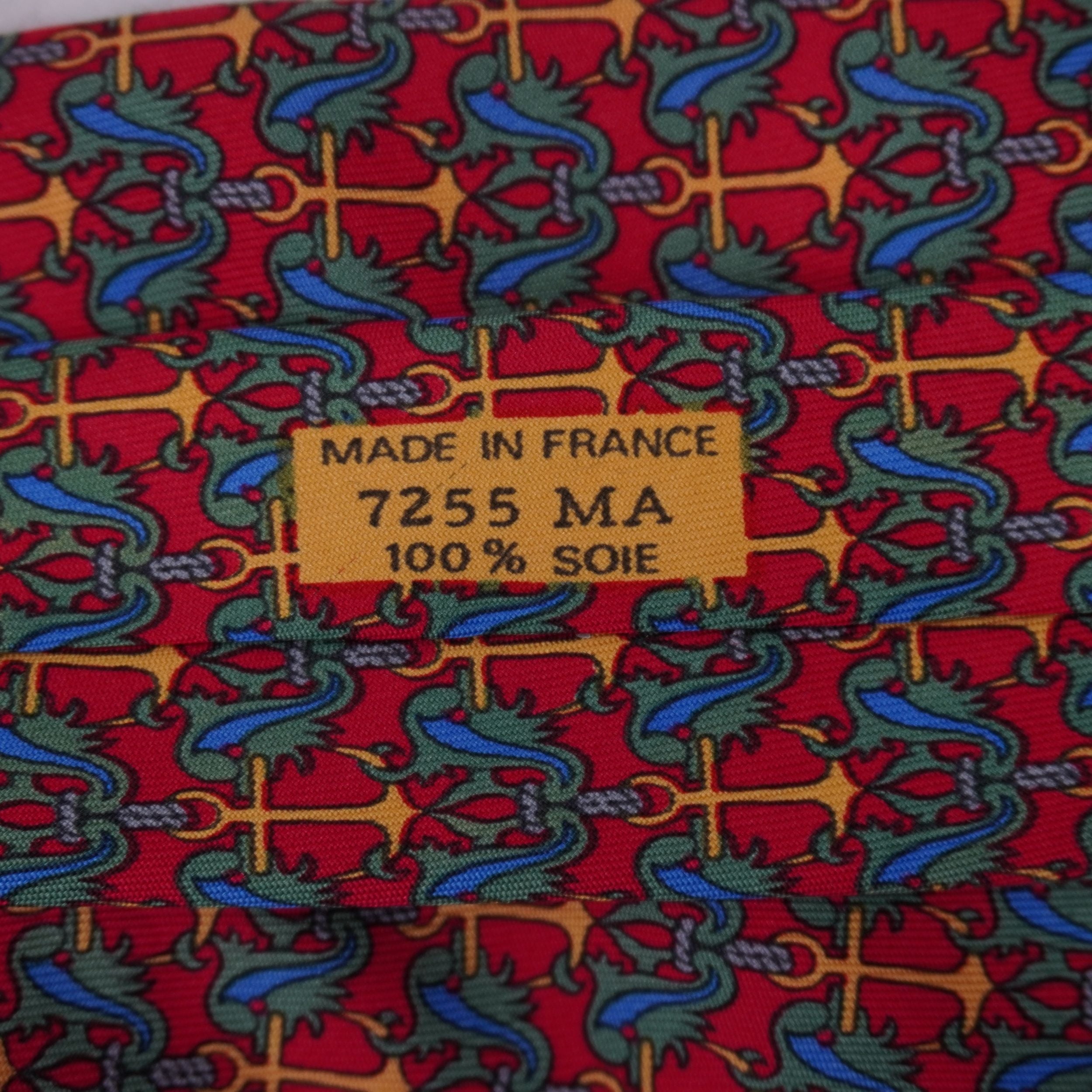 Dettaglio ravvicinato della stampa su seta gialla sul retro della cravatta Hermès che mostra la scritta Made in France e il codice 7255 MA.