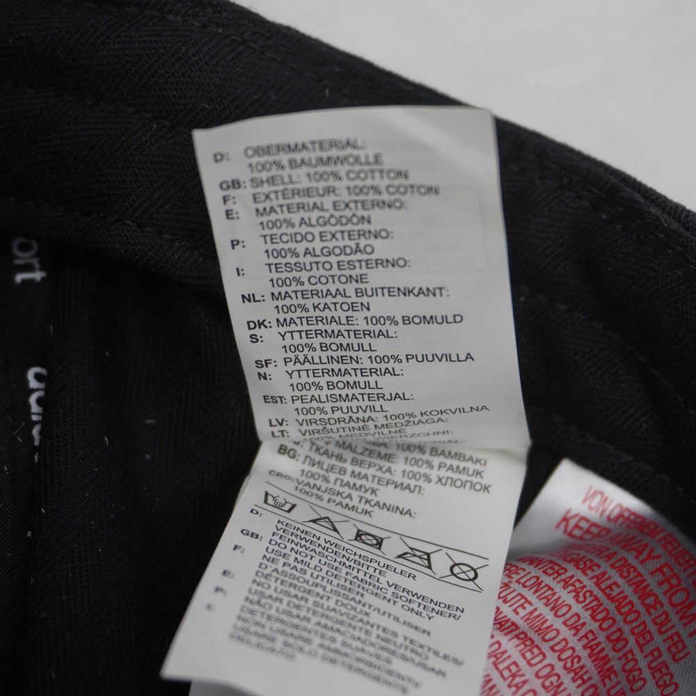 Macro del piccolo tag bianco Adidas con data di produzione 03/14 e codice articolo d'archivio M60157.