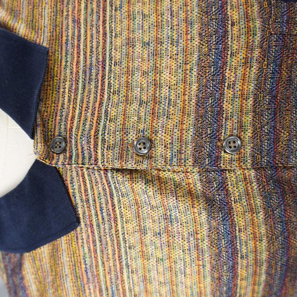 Dettaglio del colletto a coste blu navy e dell'abbottonatura frontale a tre punti della polo vintage Yves Saint Laurent.