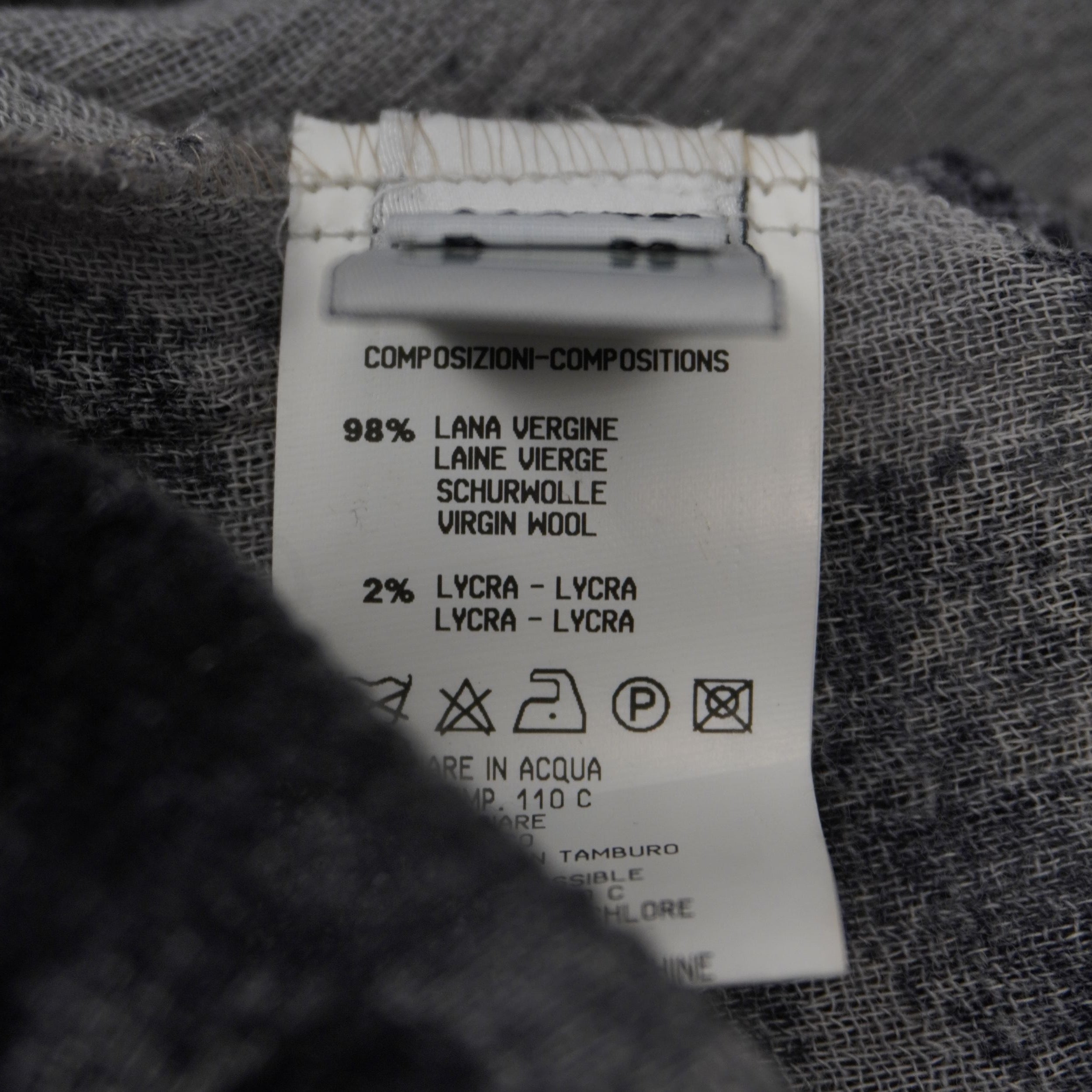 Etichetta di composizione che certifica l'utilizzo di 98% pregiata lana vergine e 2% Lycra stretch.